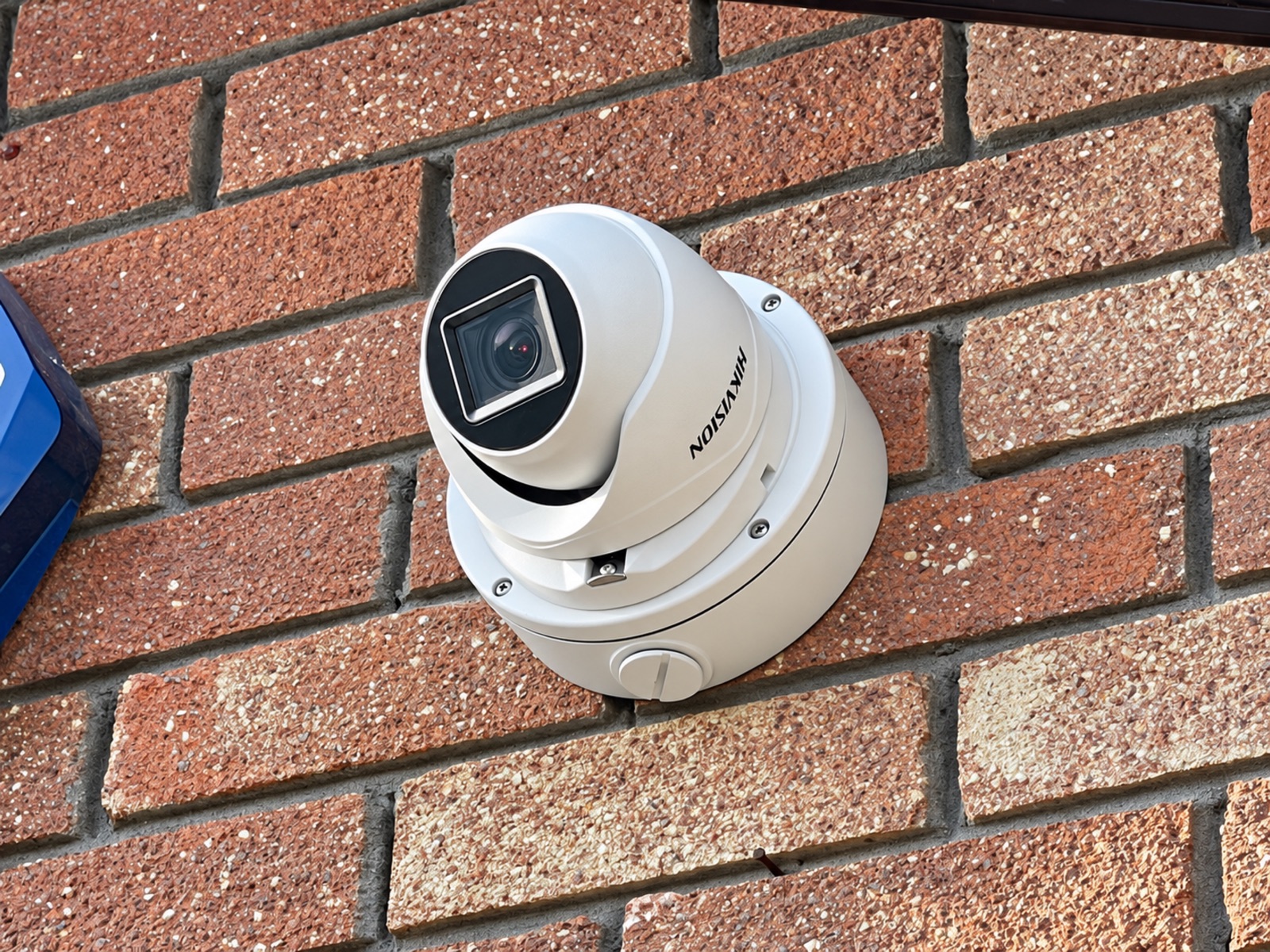 Hikvision CCTV turret camera installed on textured brickwork